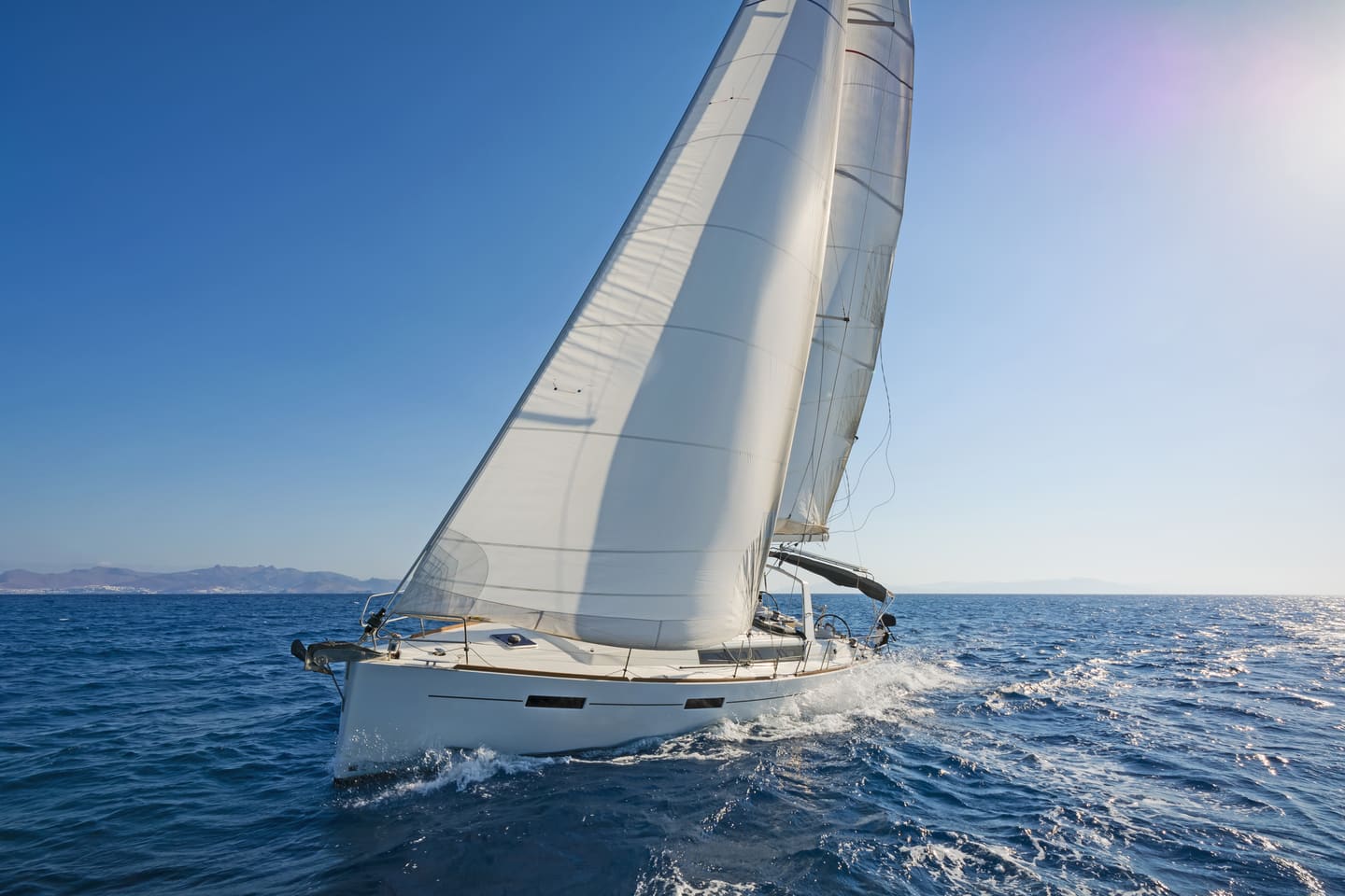 A modern yacht heeling under full sail on the open sea on a bright day